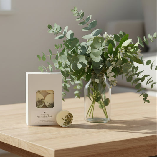 pack of six wax melts in box on coffee table with eucalyptus leaves and lemon myrtle
