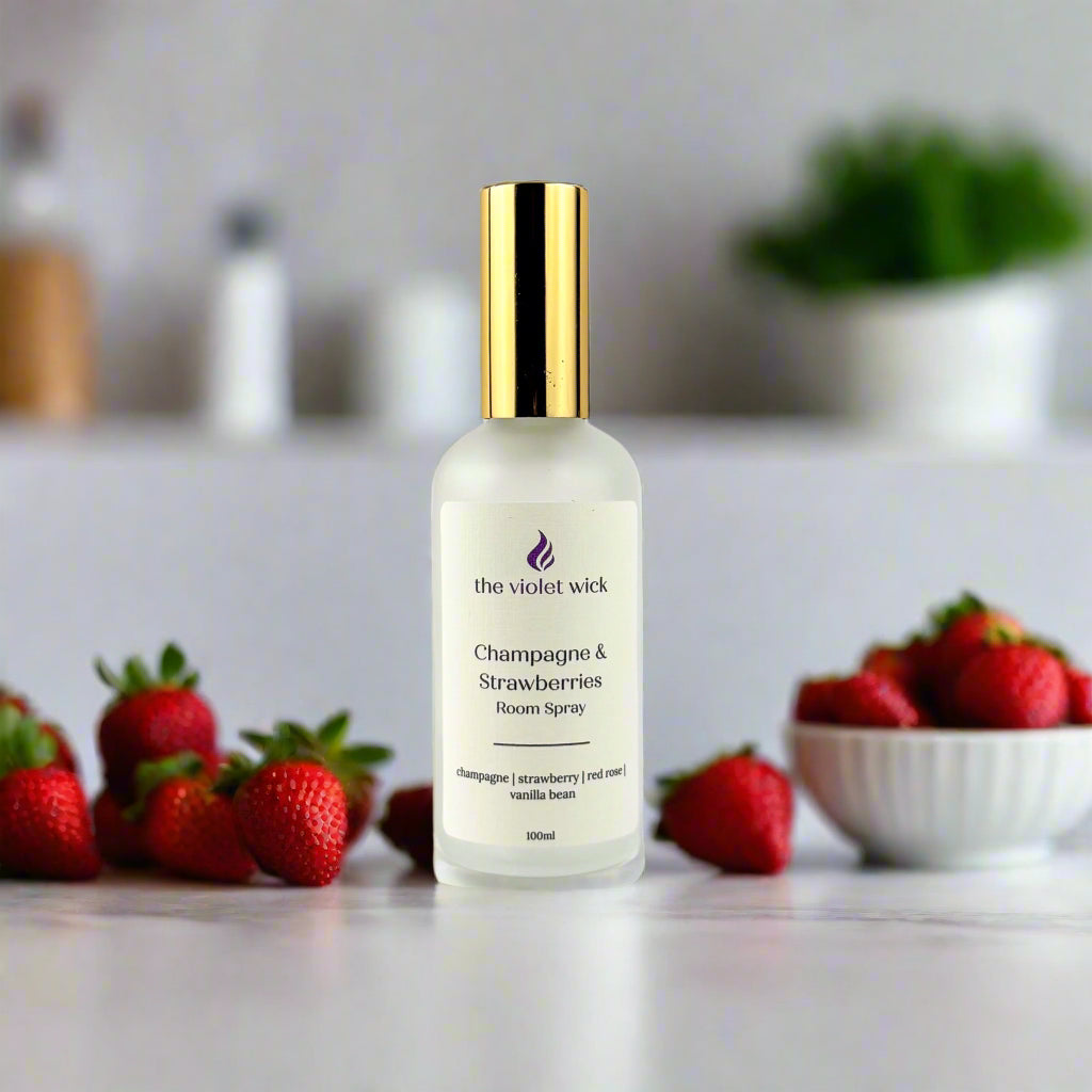 Champagne & Strawberries Room Spray by The Violet Wick on a bench with strawberries