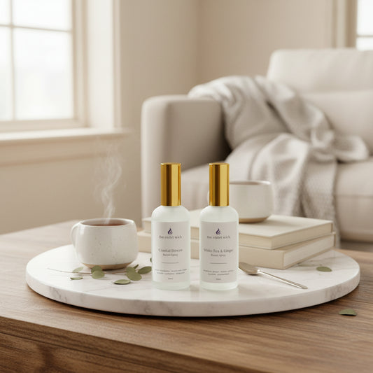 Two white room spray bottles on coffee table with living room in background