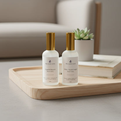 Two white room spray bottles on a tray on coffee table with living room in background