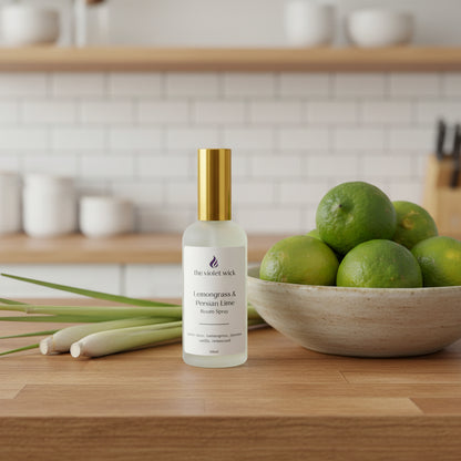 white room spray bottle labeled Lemongrass & Persian Lime on a timber kitchen bench next to bowl of limes and lemongrass stalks