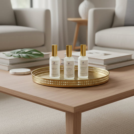 three white room spray bottles on a tray on coffee table with living room in background